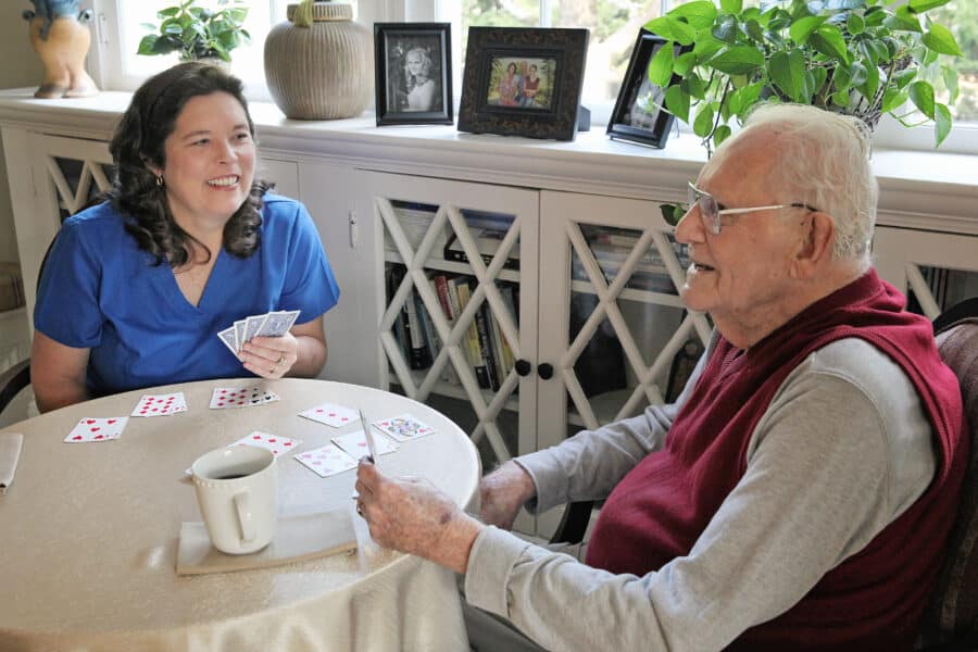 An old man with his smiling lady caregiver