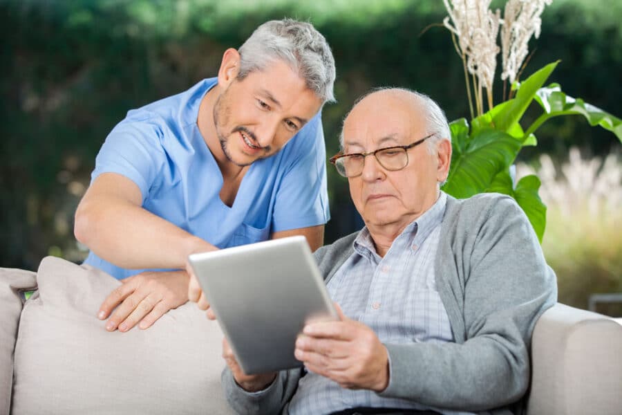 Male caregiver explaining some words to his elder patient